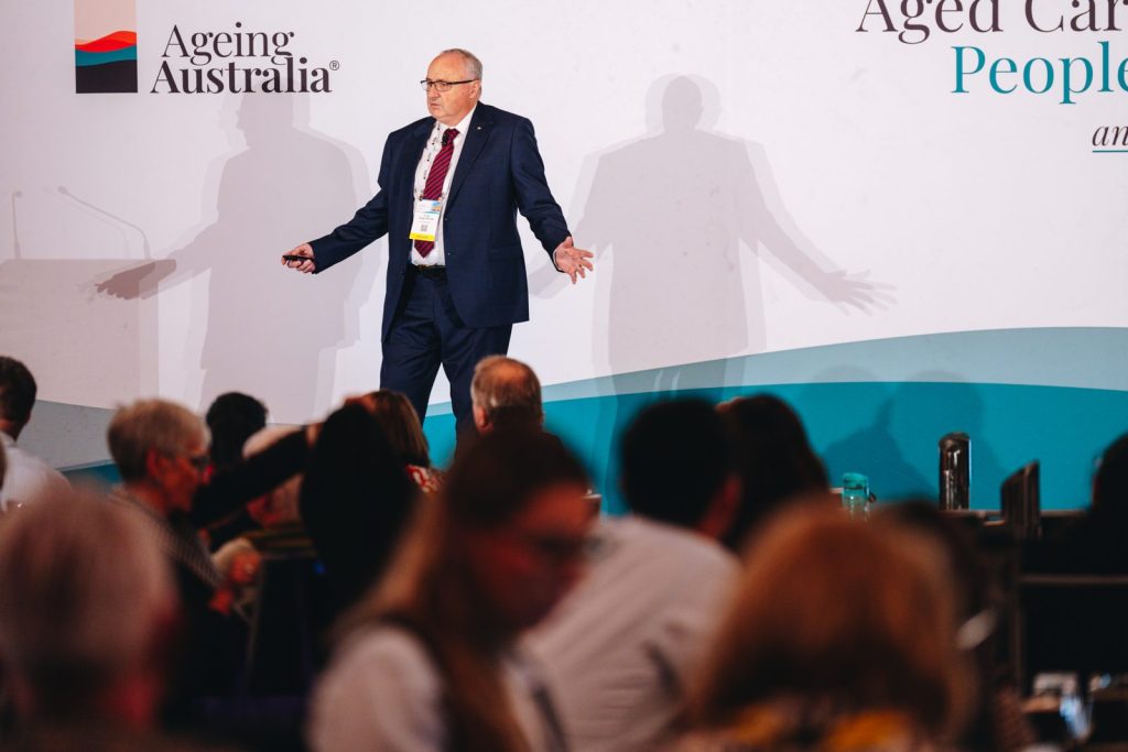 Dr Bill Griggs speaking on stage at the Ageing Australia conference