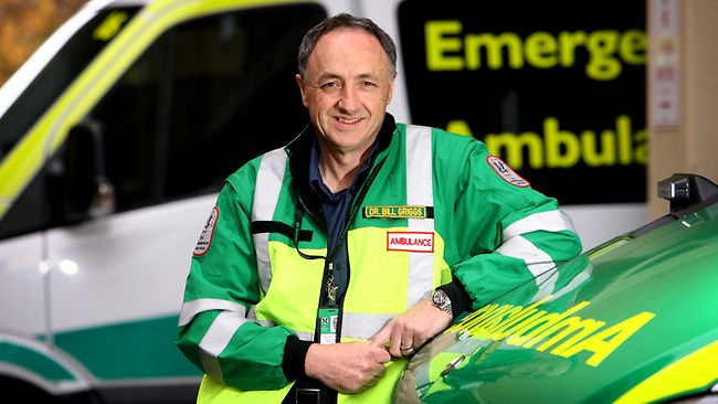 Dr Bill Griggs standing by an ambulance in an emergency medicine uniform