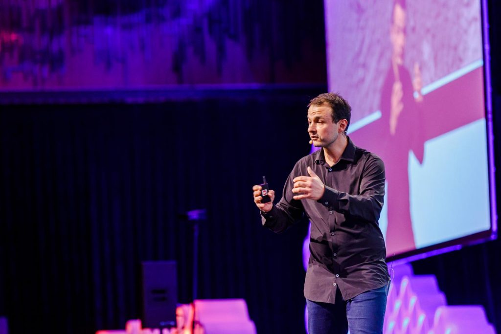 James Castrission speaking on stage