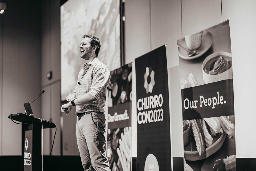 Daniel Bull speaking at a podium
