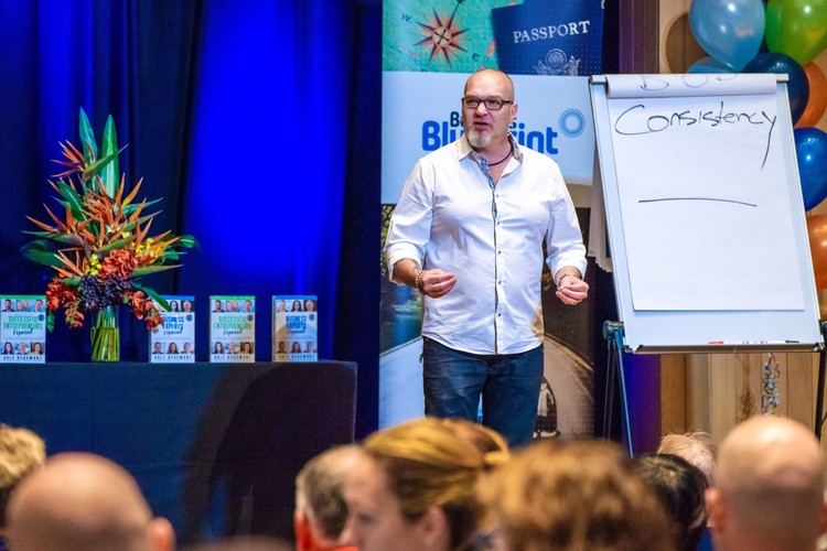 Justin Herald speaking beside a flipchart at a business event