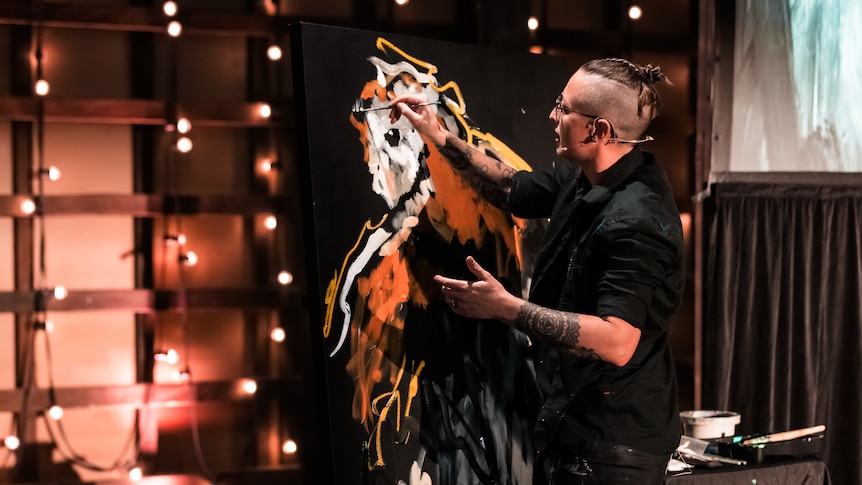 Sarah Rowan speed painting on stage at a conference