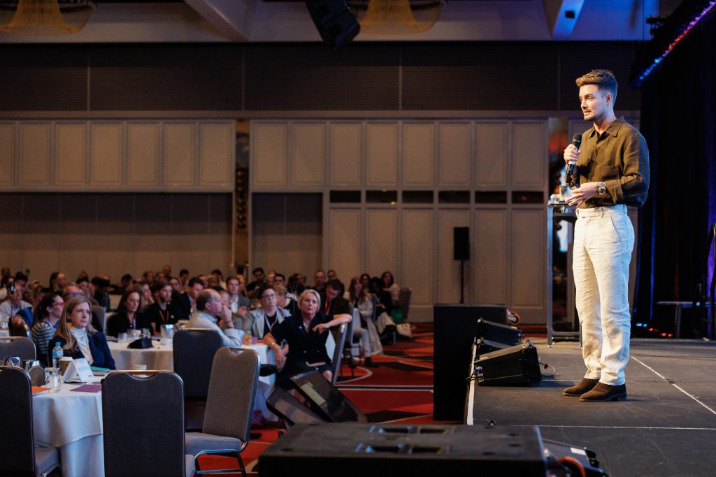 Mitch Wallis speaking to a conference audience