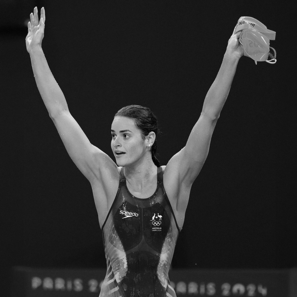 Kaylee McKeown celebrating with arms raised holding her swim cap