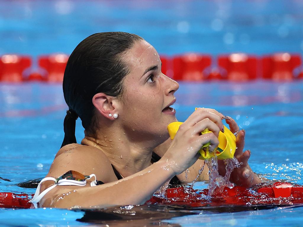 Kaylee McKeown in the pool holding her swim cap near the lane ropes
