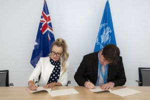 Amy Gildea signing an agreement with the UN