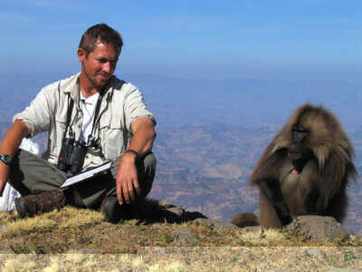 Dr Chadden Hunter with a gelada baboon in Ethiopia