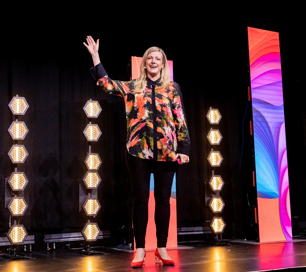 Kirryn Zerna business speaker waving in colorful outfit