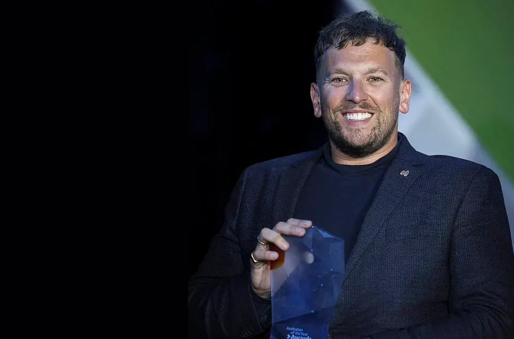 Dylan Alcott motivational speaker smiling with his Australian of the Year trophy