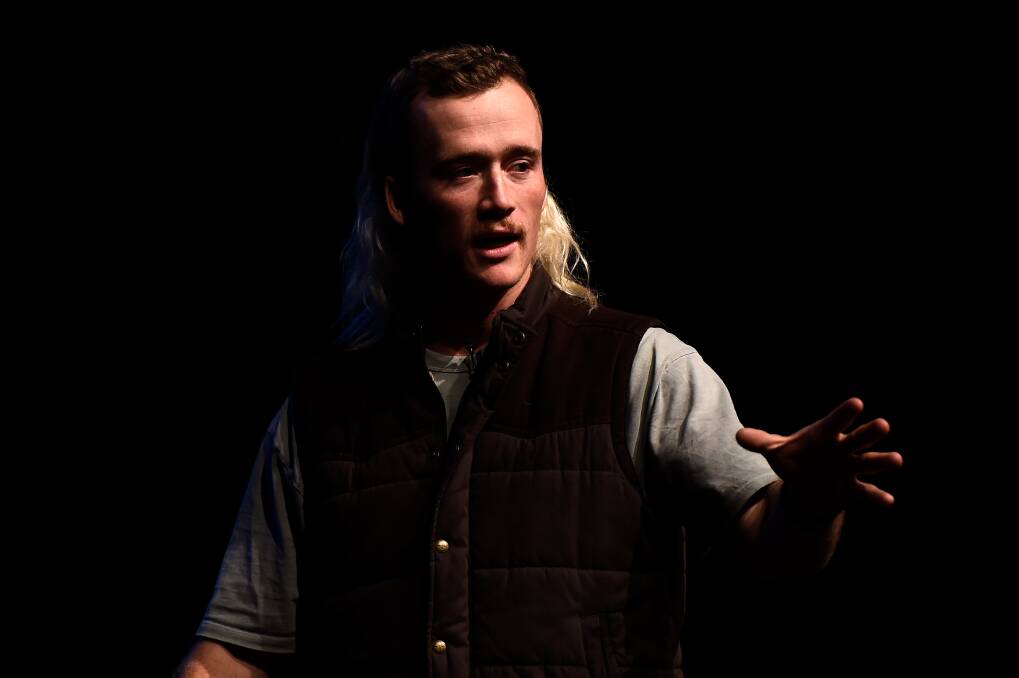 Nedd Brockmann motivational speaker presenting on a dark stage